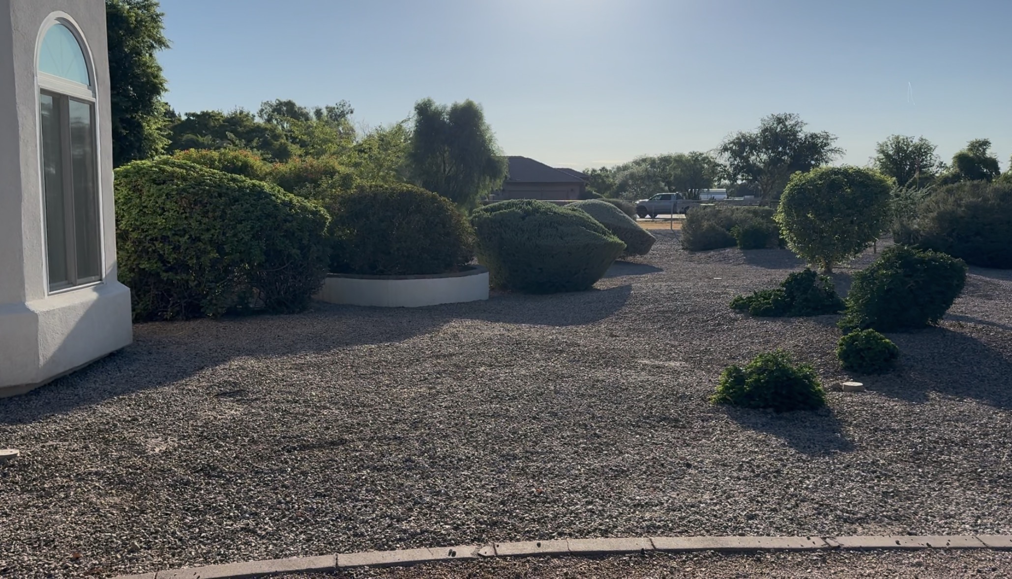 East of driveway, gap near the house